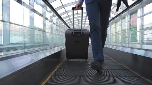 Legs of Businessman Running on Escalator in Hall of Terminal