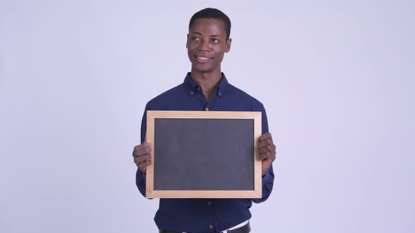 Young Happy African Businessman Holding Blackboard