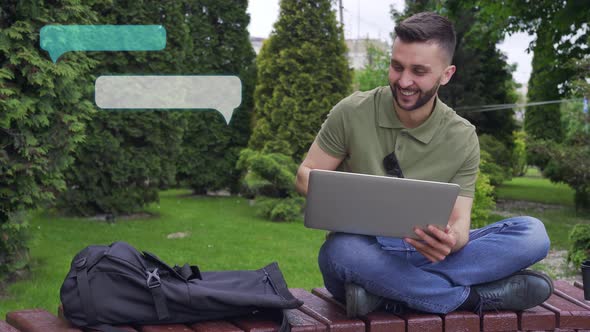 Smiling Man Using Laptop Outdoors