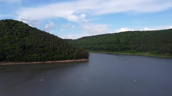 Lake Surrounded By Hills With Forest, Aerial View