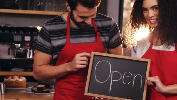 Waiter and waitress showing slate with open sign