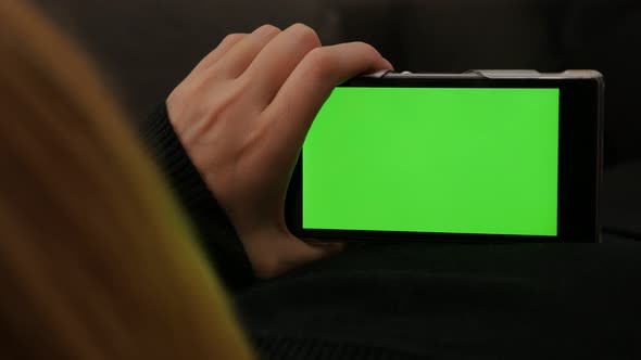 Green screen on smart phone while scrolling through pages 4K 2160p UHD footage - Woman holding cell 