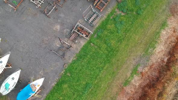 Pieces of boat in small local shipyard, aerial top down ascend view