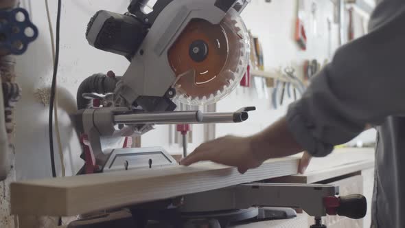 Caucasian Carpenter Preparing to Cut Wood Board on Miter Saw