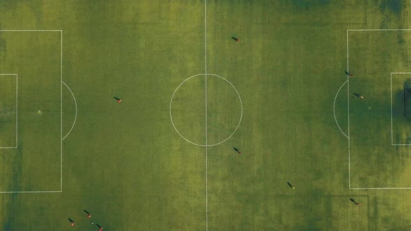 Aerial View of Football Team Practicing at Day on Soccer Field in Top View