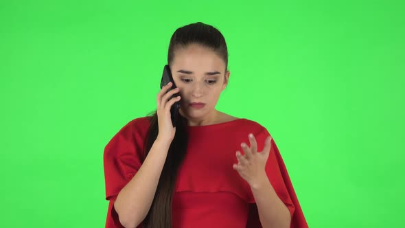 Portrait of Pretty Young Woman Is Angrily Speaking on the Phone, Proving Something. Green Screen