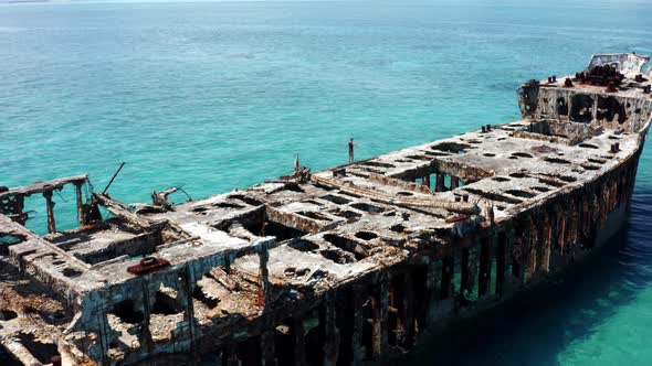 Aerial View, Lonely Female Walking on Shipwreck in Decay in Tropical Sea Water. SS Sapona, Bimini, B