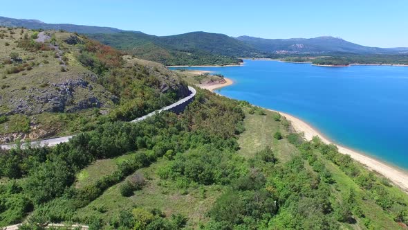 Aerial view of empty paved road passing artificial lake of Peruca, Croatia