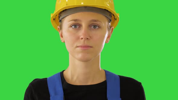 Young Attractive Caucasian Woman Builder in the Hard Yellow Helmet on a Green Screen, Chroma Key