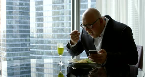 Businessman in a Suit, He Sits in His Office's Panoramic Window in Which You Can See High-rise