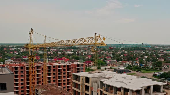 Aerial Drone View. High Cranes Works on Building Site with a House. Flight From Bottom To Top