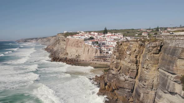 Beautiful long waves at west coast of Portugal. Picturesque town of Azenhas do Mar