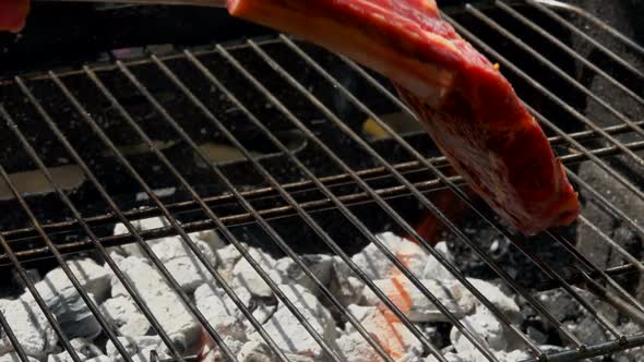 Chef Puts Steak Using Tongs on the Grill Grate