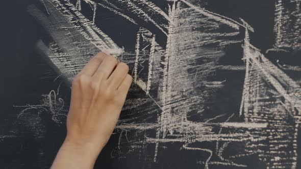 Hand of woman drawing on chalkboard