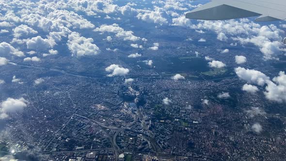 Modern downtown Paris city seen from the window of an airplane above the clouds.