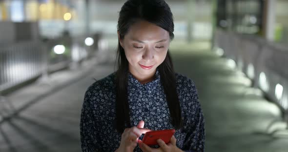 Woman read on smart phone in city at night