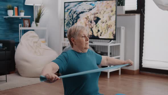 Close Up of Pensioner Pulling Resistance Band to Stretch Arms