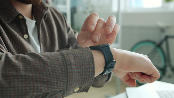 Close-up of Guy's Hand Swiping Digital Watch Screen Checking Messages with Smart Device
