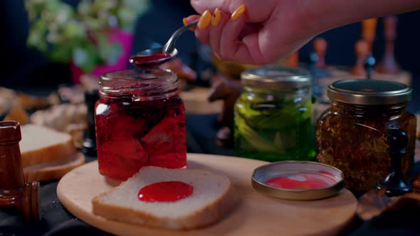 Closeup of Small Jar with Jam and Piece of Bread on Wooden Board