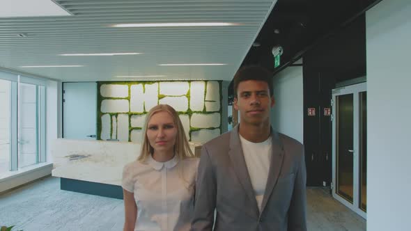 Multiethnic Coworking Man and Woman in Office. Young Blond Woman and African-American Man in Suit