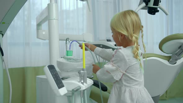 Little Girl Checks Saliva Ejector in Cabinet