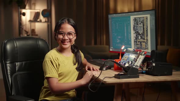 It Asian Girl Is Working With Desktop Computer And Mainboard In Home, She Turns And Warmly Smiles