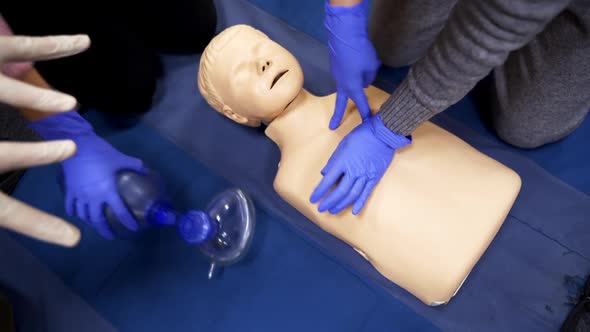 Training on a medical mannequin doll. Learning to do chest compression on a dummy.