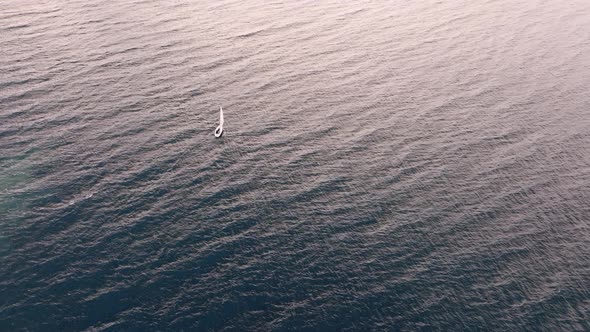 Lonely boat sailing on a lake at sunset.