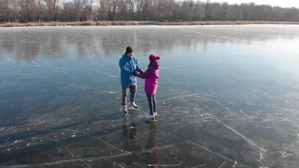 Happy Couple Ice Skating Outdoors on a Frozen Lake on a Lovely Sunny Winter Day. Ice Skating Lovely