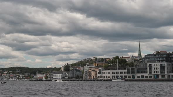 Boats Sailing On The Calm Water In Arendal, Norway On A Cloudy Weather - Cityscape View In The Backg