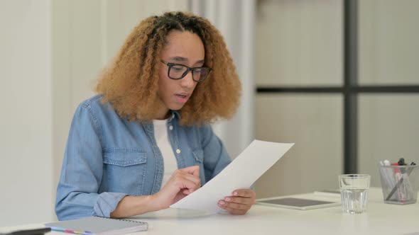 Excited African Woman Celebrating While Reading Papers