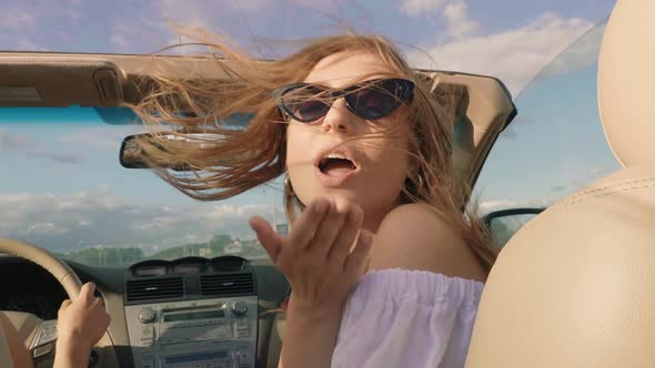 Young beautiful and smiling hipster girl in convertible car