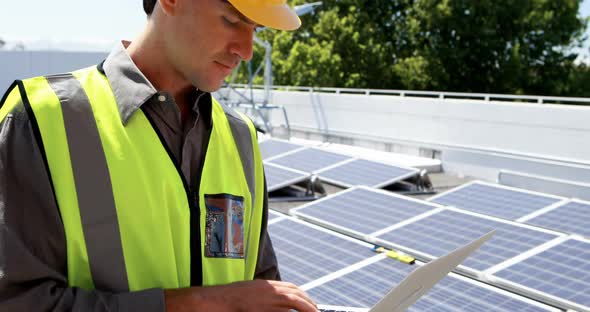 Male worker using laptop at solar station 4k