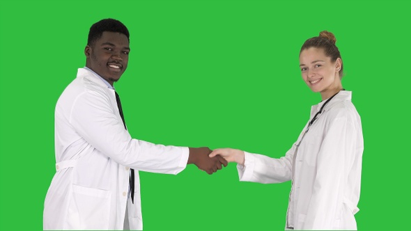 Doctors shaking hands and posing to camera on a Green Screen