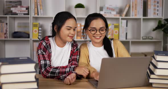 Twin asian girls using laptop to learning online