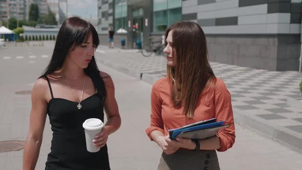 Two Female Business People Drinking Coffee at the End of the Day and Talk to Hot Gossip Near Parking