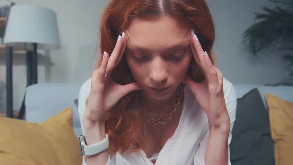 Close Up of Upset Young Red Haired Woman Coping with Headache Migraine