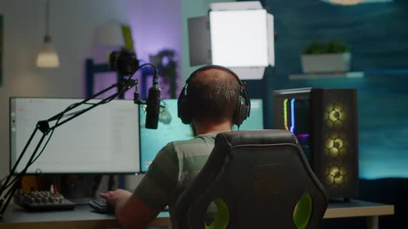 Back Shot of Streamer Man Playing on Powerful Computer Shooter Video Game
