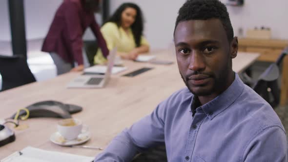 Portrait of smiling african american businessman looking at camera in modern office