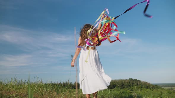 Teenage Girl with Rainbow Ribbons on Nature