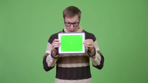 Young Handsome Man Showing Digital Tablet and Looking Shocked