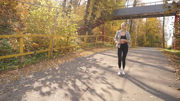 Beautiful Young Woman Running in the Forest on a Sunny Morning in the Fresh Air