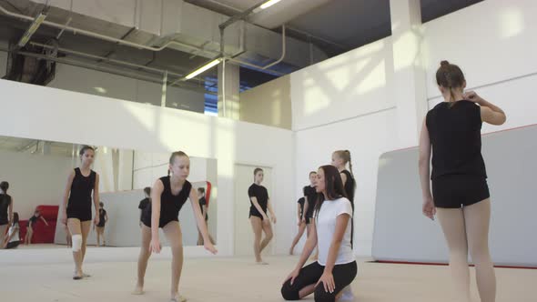 Woman Coaching Girls during Gymnastics Practice