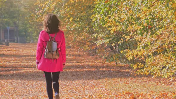 Happy Attractive Caucasian Woman Walking in Autumn Alley