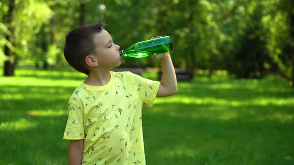 Boy drinking water from a bottle in the park