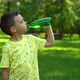 Boy drinking water from a bottle in the park - VideoHive Item for Sale