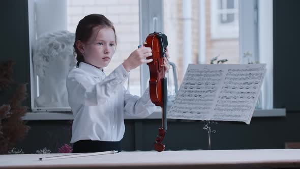 A Little Girl Putting Together the Violin Piece By Piece and Starts Playing