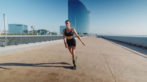 Sportswoman Riding Roller Blades on Embankment