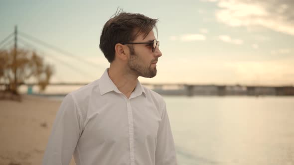 Lonely Romantic Guy In Sunglasses Walks On Sand And Dreaming. Man Walking On City Beach.