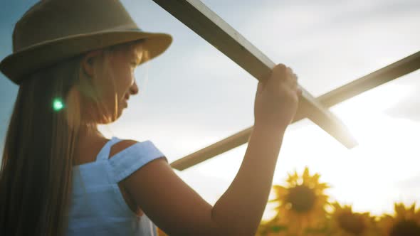 Cute Child Playing with Toy Wooden Airplane in the Field at Sunset Time